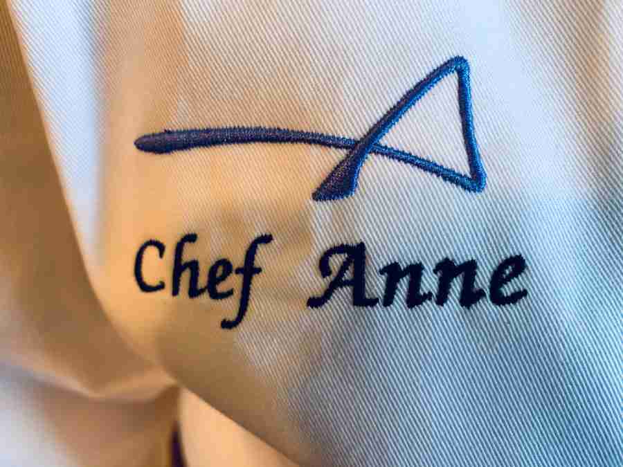 Chef Anne new white chef coat with Artist Anne blue "A" logo