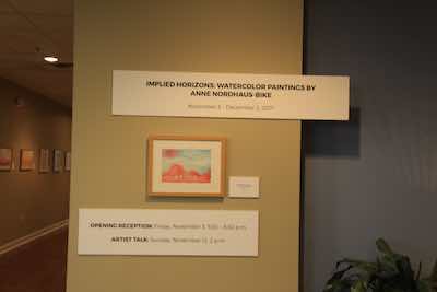 Art exhibit title, painting, and other placards at installation day